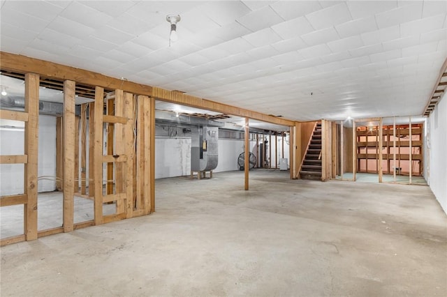 unfinished below grade area featuring stairway and heating unit