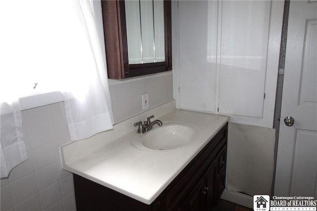 bathroom featuring vanity, decorative backsplash, and tile walls