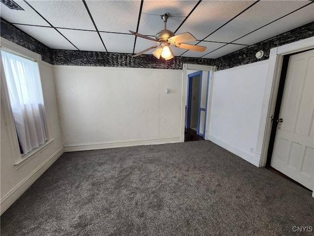 unfurnished room featuring carpet flooring, a ceiling fan, baseboards, and a drop ceiling