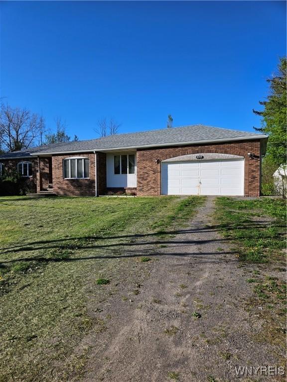 3159 Upper Mountain Rd, Cambria, NY 14132 - view of front facade with driveway, an attached garage, brick siding, and a front yard