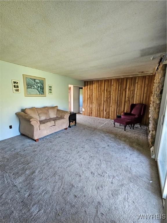 3159 Upper Mountain Rd, Cambria, NY 14132 - carpeted living area with a textured ceiling and wood walls