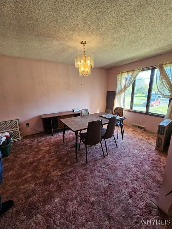 3159 Upper Mountain Rd, Cambria, NY 14132 - dining space with carpet flooring, a chandelier, and a textured ceiling