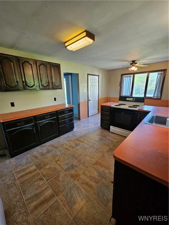 3159 Upper Mountain Rd, Cambria, NY 14132 - kitchen with electric stove, ceiling fan, a sink, and stone finish floors