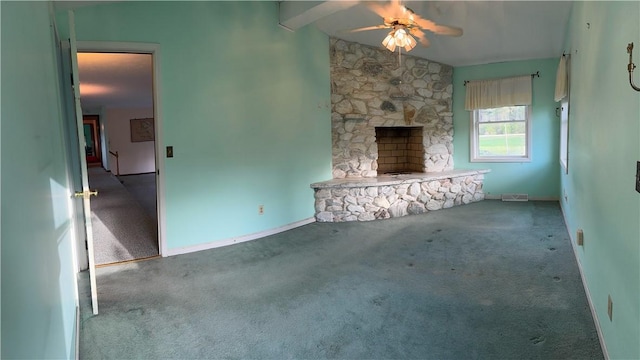 1142 W Ave, Clarkson, NY 14420 - unfurnished living room featuring carpet, ceiling fan, a stone fireplace, and baseboards
