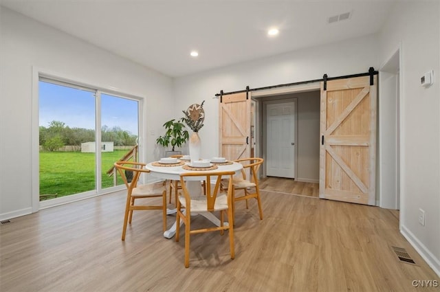161 Knapps Knolle Rd, Schuyler, NY 13502 - dining area featuring a barn door, light wood-type flooring, recessed lighting, and baseboards