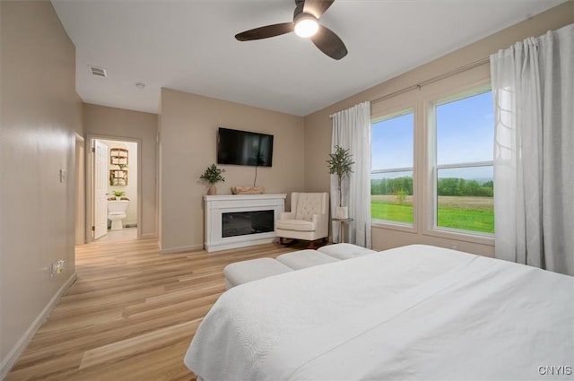 161 Knapps Knolle Rd, Schuyler, NY 13502 - bedroom featuring baseboards, light wood-style flooring, a glass covered fireplace, and ceiling fan