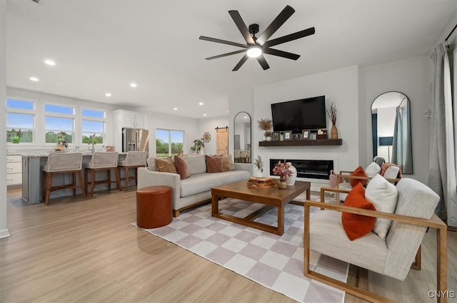 161 Knapps Knolle Rd, Schuyler, NY 13502 - living area with light wood-type flooring, a glass covered fireplace, recessed lighting, a ceiling fan, and arched walkways