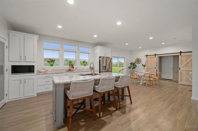 161 Knapps Knolle Rd, Schuyler, NY 13502 - kitchen featuring stainless steel fridge, black microwave, a sink, a barn door, and a center island with sink