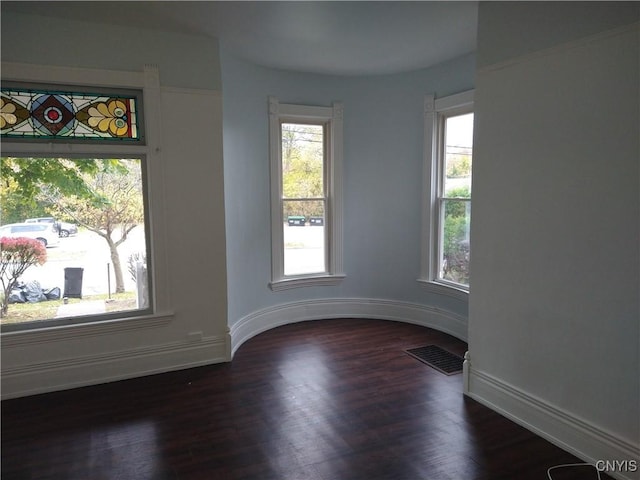 406 Milton Ave, Syracuse, NY 13204 - empty room with healthy amount of natural light, dark wood-type flooring, and baseboards