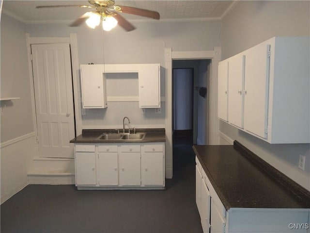 406 Milton Ave, Syracuse, NY 13204 - kitchen featuring a sink, ceiling fan, dark countertops, ornamental molding, and white cabinetry