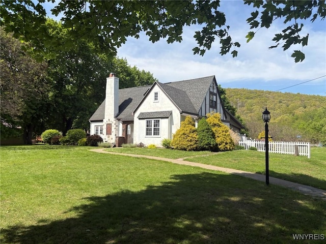 view of front of home featuring a chimney, stucco siding, and a shingled roof