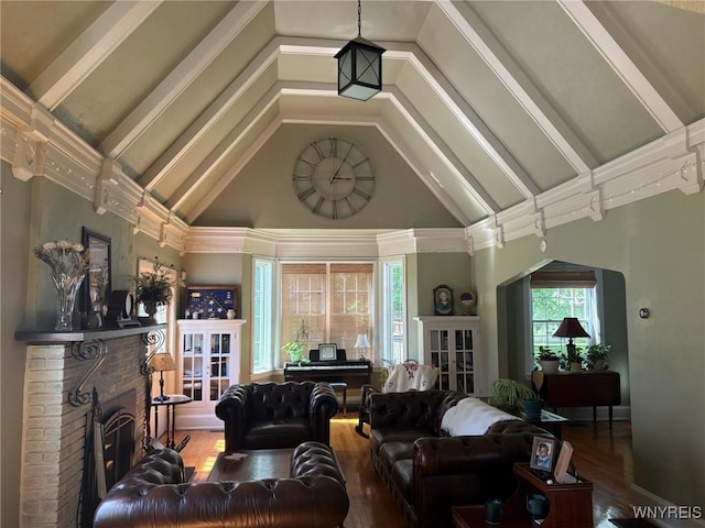 living room featuring a brick fireplace, wood finished floors, and high vaulted ceiling