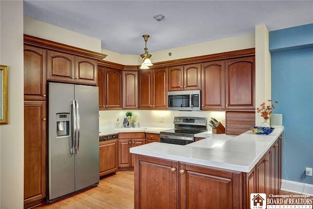 14 S Lake Dr Unit 2B, Chautauqua, NY 14722 - kitchen featuring stainless steel appliances, a peninsula, light countertops, light wood-style floors, and hanging light fixtures