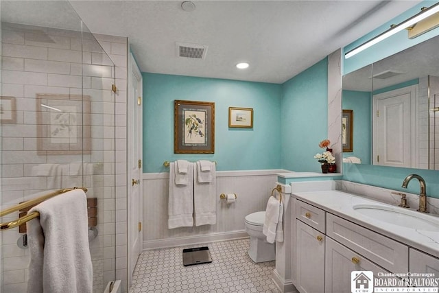 14 S Lake Dr Unit 2B, Chautauqua, NY 14722 - bathroom featuring tiled shower, toilet, vanity, and a wainscoted wall
