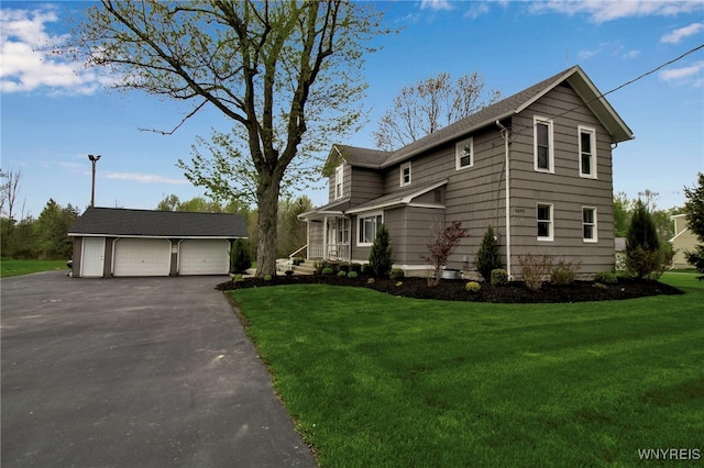 traditional-style home with an outdoor structure, a garage, and a front yard