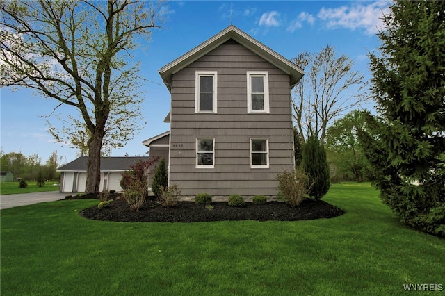 view of property exterior with a yard and concrete driveway