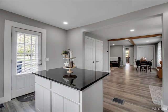 kitchen featuring light wood finished floors, a kitchen island, healthy amount of natural light, white cabinets, and recessed lighting
