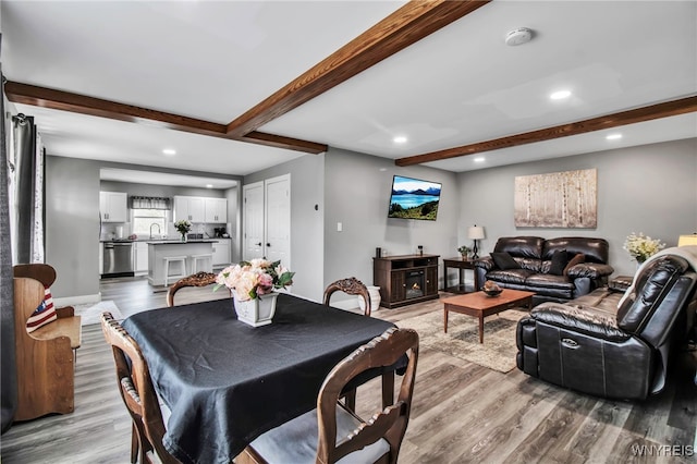 dining room featuring light wood-style floors, beamed ceiling, and recessed lighting