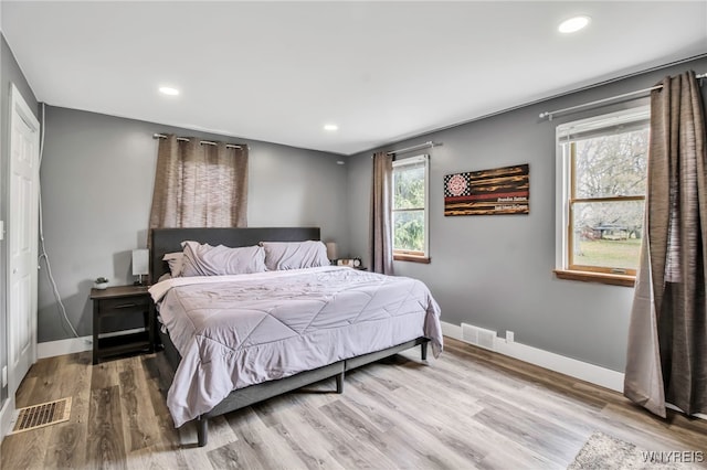 bedroom featuring baseboards, recessed lighting, and wood finished floors