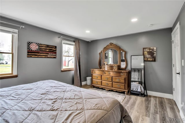 bedroom featuring wood finished floors, recessed lighting, and baseboards