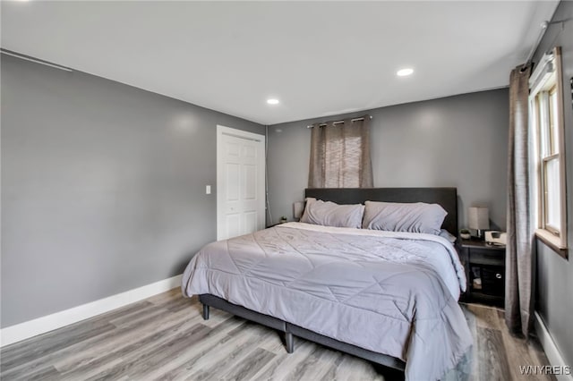 bedroom with baseboards, light wood-type flooring, and recessed lighting