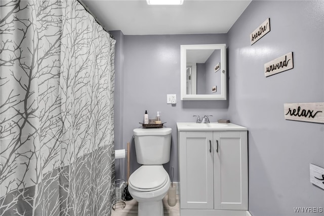 full bathroom with toilet, vanity, and baseboards