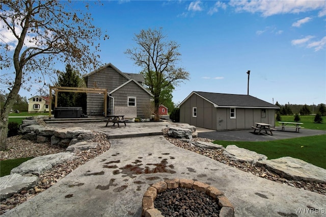 rear view of property with a patio, a hot tub, and a pergola