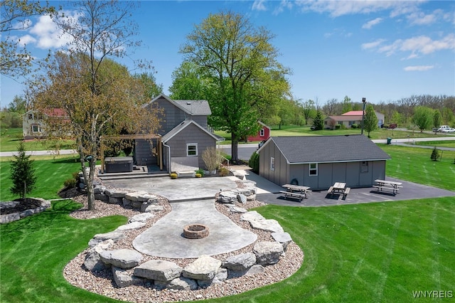 back of house featuring a fire pit, a patio, a lawn, and an outdoor structure
