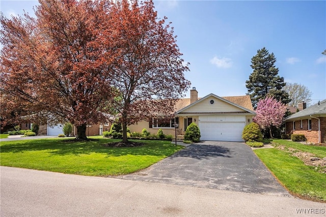 view of front of property featuring a front lawn, driveway, an attached garage, and a chimney
