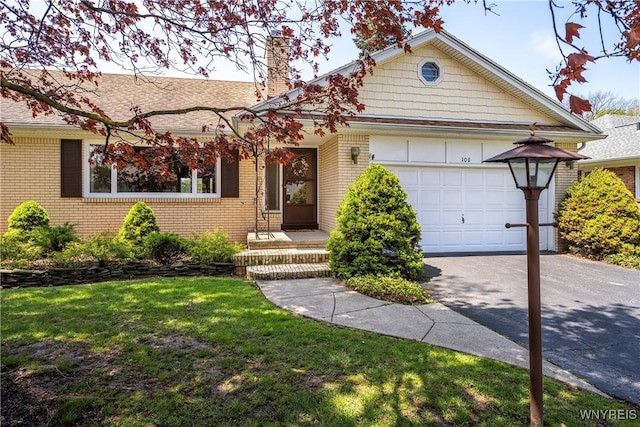 ranch-style home with brick siding, concrete driveway, a chimney, an attached garage, and a front yard