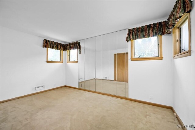 carpeted empty room featuring baseboards