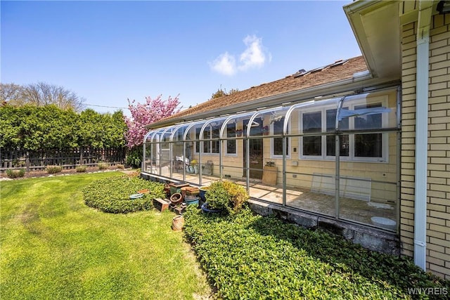 rear view of property featuring a sunroom