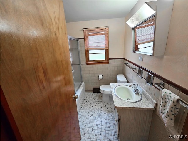 585 Downing St, Buffalo, NY 14220 - full bathroom with tile walls, vanity, wainscoting, and combined bath / shower with glass door