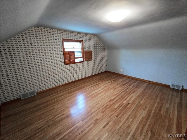 585 Downing St, Buffalo, NY 14220 - bonus room with vaulted ceiling, wood finished floors, and wallpapered walls