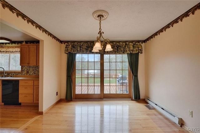 43 County Rte 9, Rossie, NY 13642 - unfurnished dining area featuring a baseboard radiator, a chandelier, light wood-type flooring, and healthy amount of natural light