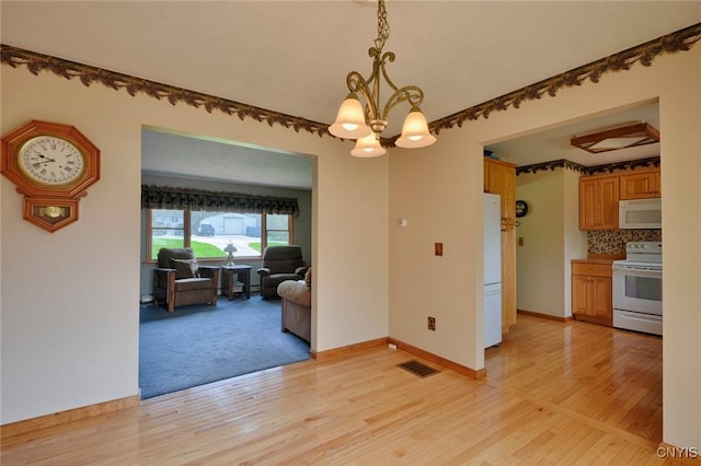 43 County Rte 9, Rossie, NY 13642 - dining room with a chandelier, light wood-type flooring, and baseboards