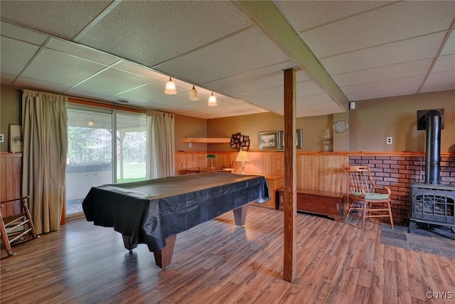 43 County Rte 9, Rossie, NY 13642 - rec room featuring a wood stove, wood finished floors, wooden walls, a drop ceiling, and wainscoting