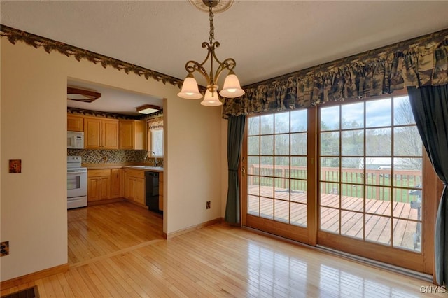 43 County Rte 9, Rossie, NY 13642 - unfurnished dining area featuring a sink, baseboards, a chandelier, and light wood-style flooring