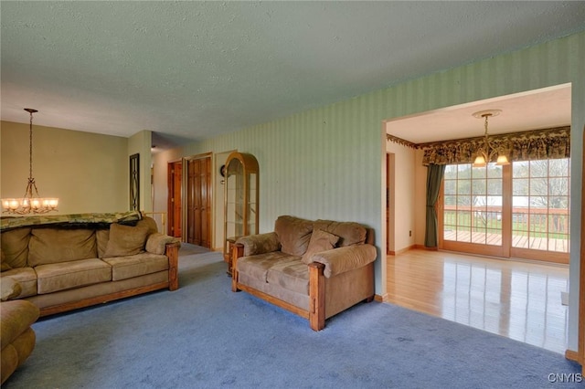 43 County Rte 9, Rossie, NY 13642 - living room featuring a chandelier, carpet flooring, a textured ceiling, and wallpapered walls