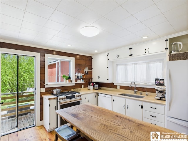 kitchen with white appliances, a sink, light countertops, and white cabinets