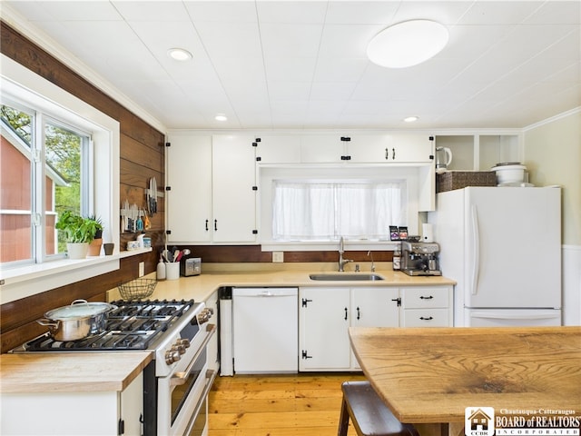 kitchen with white appliances, a sink, white cabinetry, light countertops, and recessed lighting