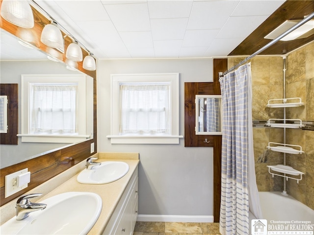 full bathroom with healthy amount of natural light, double vanity, and shower / bath combo with shower curtain