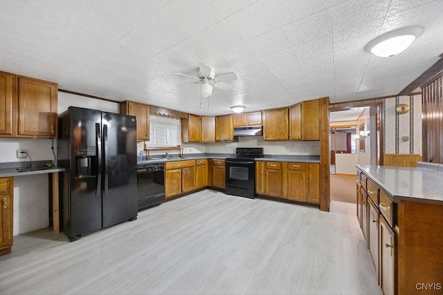 kitchen with black appliances, under cabinet range hood, brown cabinetry, light wood-type flooring, and ceiling fan