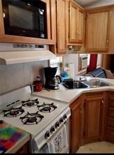 1984-2008 S Genesee St, Montour, NY 14865 - kitchen with white gas stove, black microwave, light countertops, and brown cabinetry