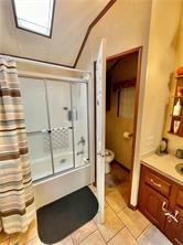 1984-2008 S Genesee St, Montour, NY 14865 - bathroom featuring toilet, vanity, bath / shower combo with glass door, and tile patterned floors