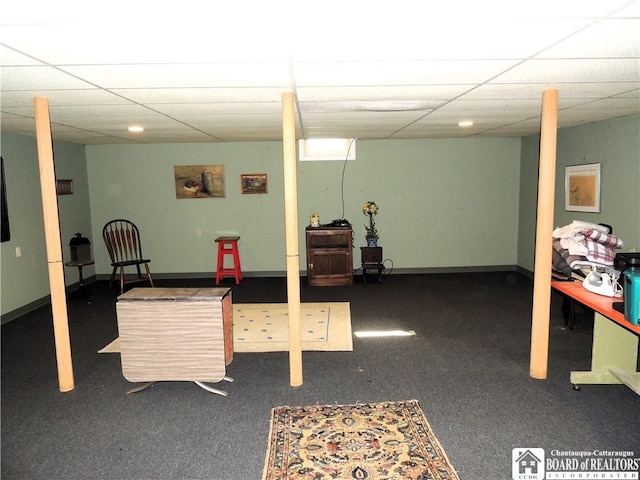 finished basement featuring a paneled ceiling and carpet