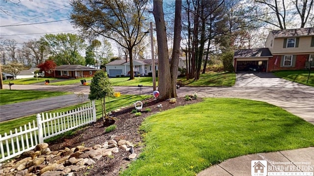 view of yard featuring concrete driveway and a residential view