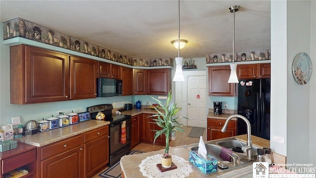 kitchen featuring black appliances, a sink, light countertops, and decorative light fixtures