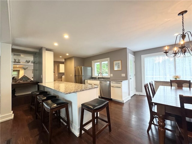 5 Walnut Street Ext, Sennett, NY 13021 - kitchen featuring appliances with stainless steel finishes, a chandelier, dark wood-type flooring, a kitchen breakfast bar, and baseboards