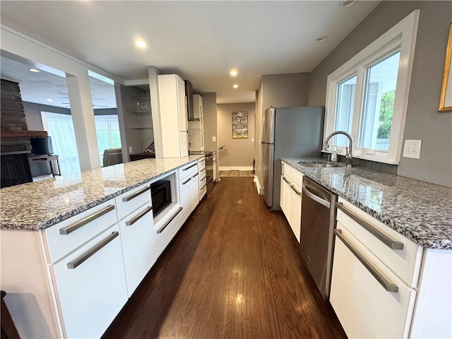 5 Walnut Street Ext, Sennett, NY 13021 - kitchen featuring stainless steel appliances, a sink, light stone counters, dark wood-style flooring, and a peninsula